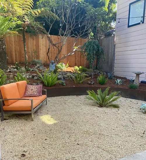 Tropical Plants, Buddha Figurine, and Gravel Patio