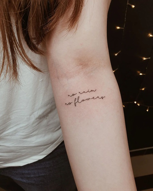 No Rain No Flowers tattoo in hand