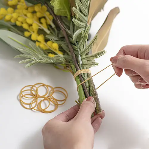 Bouquet wrapped with rubber band around branch